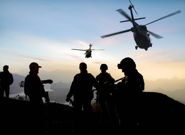 silhuetas de soldados durante missão militar ao anoitecer - military technology - fotografias e filmes do acervo