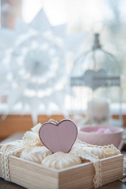 Food styling for saint Valentine's Day with wooden heart, zephyr, meringue, flowers and wooden decor