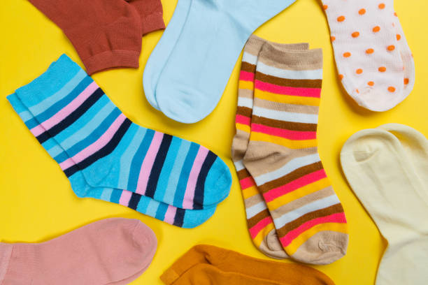 istock Multi-colored socks on a yellow background. View from above. Many different socks for cold seasons 1297826507