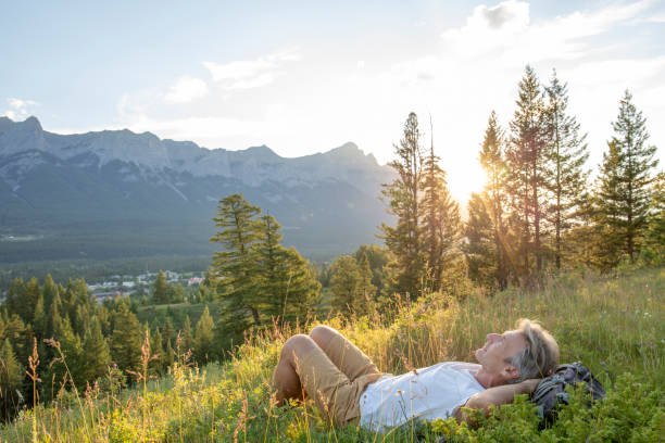 istock Mature hiker reclines in mountain meadow at sunset 1297829901