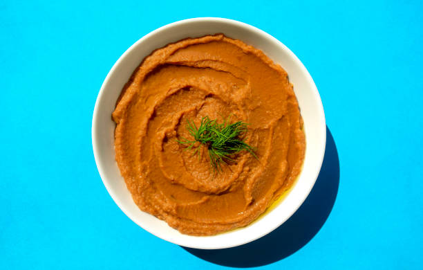 istock Famous traditional Arabic cuisine - peeled fava beans mashed plain in white bowl on blue background. 1297830251