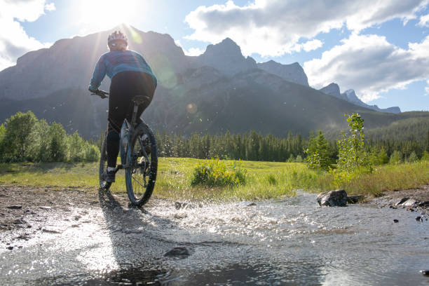 istock Woman mountain biker rides across a mountain stream 1297831040