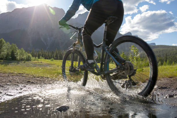 istock Woman mountain biker rides across a mountain stream 1297831054