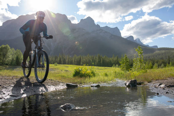 istock Woman mountain biker rides across a mountain stream 1297831055