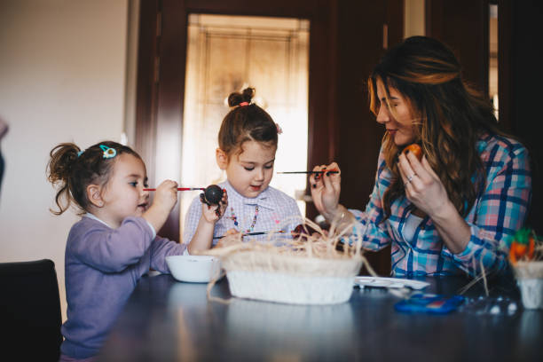 istock Girls are amused while decorating eggs for Easter. 1297831617