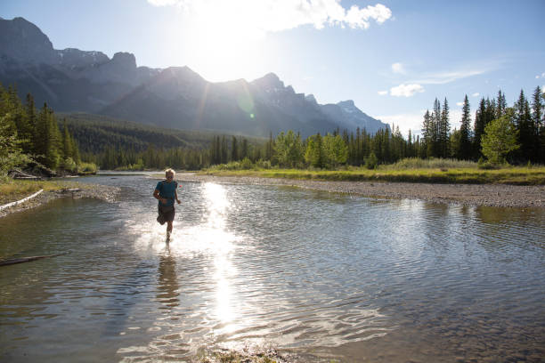 istock Man runs across shallow water, sunrise over mountains 1297832249