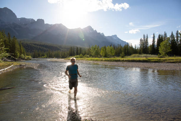 istock Man runs across shallow water, sunrise over mountains 1297832262