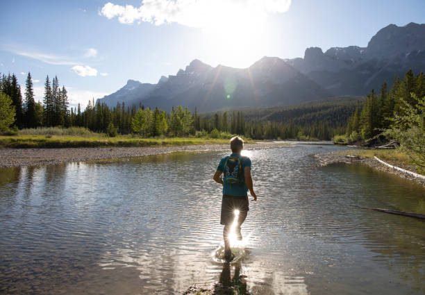 istock Man runs across shallow water into sunrise over mountains 1297832360