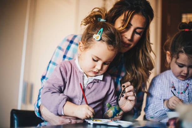 istock Girls with their mom mixing colors for decorating Easter eggs 1297833736