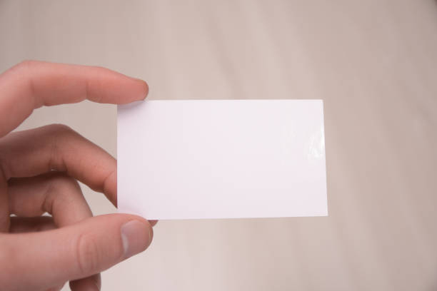 istock Hand hold blank white card mockup with rounded corners. Plain call-card mock up template holding arm. Plastic credit namecard display front. Check offset card design. Business branding. 1297834228