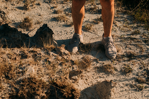 Legs of an unrecognizable man in sneakers ready to run in nature, a close up