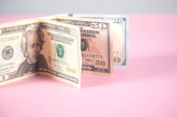 istock money on the pink background 1297836545