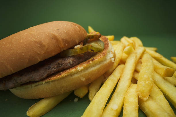 Macrophotography of a hamburger and french fries on a green background