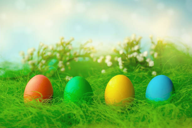 istock Happy Easter. A row of decorative multicolored Easter eggs on the green grass. 1297837078