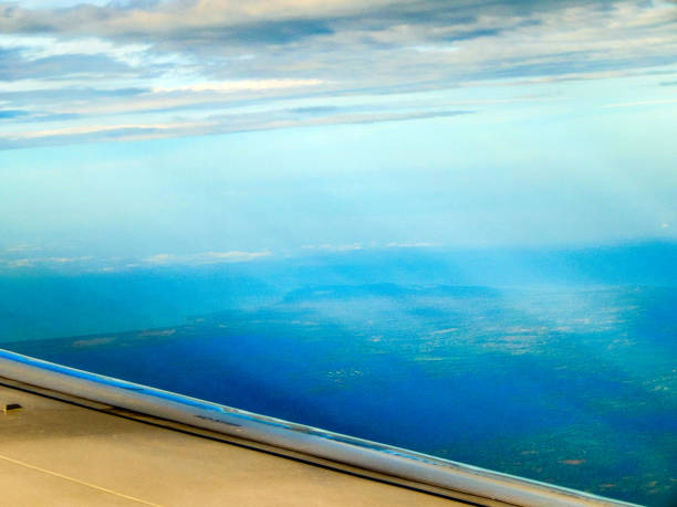 istock Sun rays passing through the clouds towards the ground seen from an airplane 1297840354