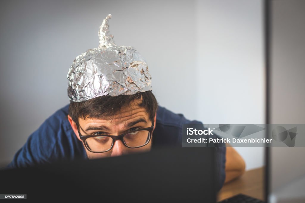 Conspiracy theory concept: young man is wearing aluminum head Young man is wearing aluminum cap, conspiracy theory concept 30-34 Years Stock Photo