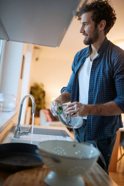 istock A diligent young man doing housework in the kitchen. Kitchen, housework, quarantin, home 1297844822