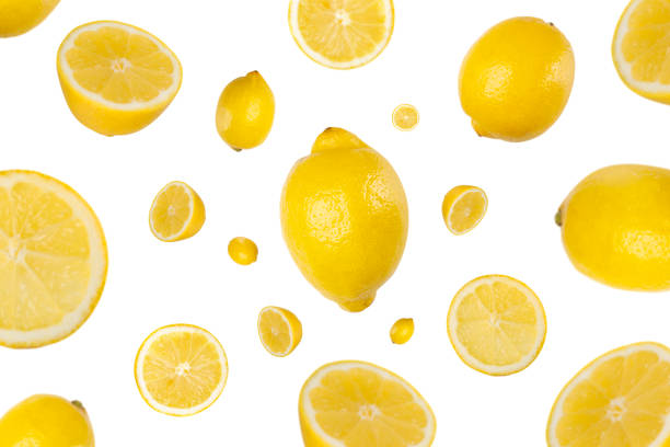 Many lemons and slices fly and fall isolated on a white background. Healthy juicy citrus fruits for summer time stock photo