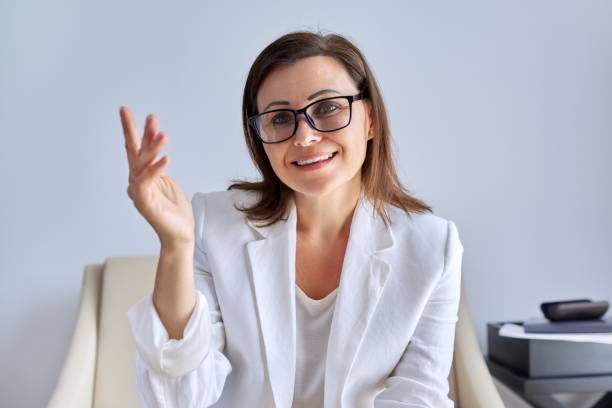 istock Positive talking middle aged business woman looking at webcam 1297846306