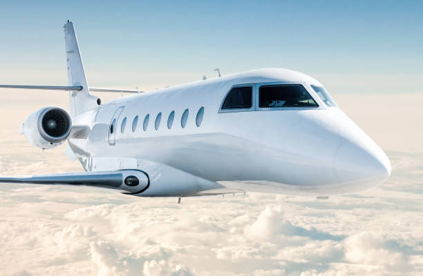 white modern luxury business jet flies in the air above the clouds - corporate jet imagens e fotografias de stock