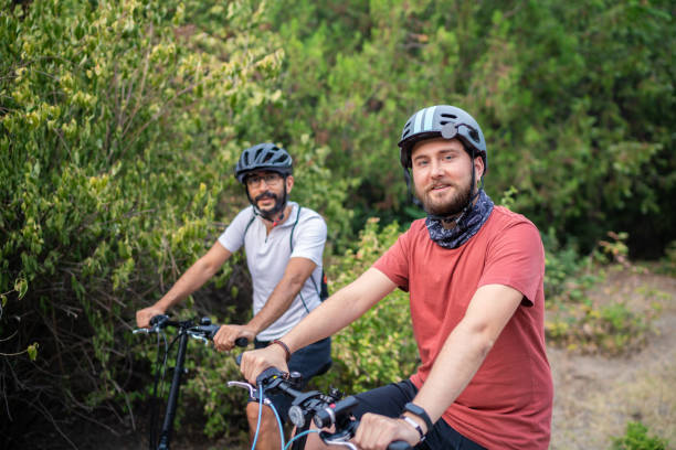 istock Smiling two young men riding bicycles 1297847743