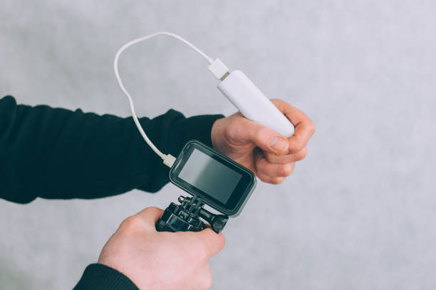 istock A man is charging an action camera with a portable charger. 1297851198