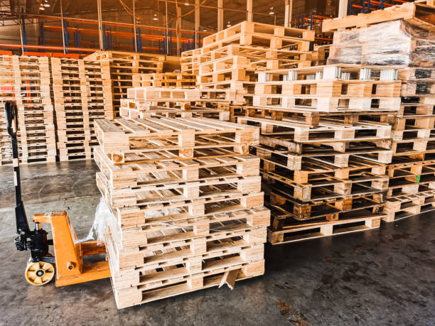 istock Worker driving forklift loading shipment carton boxes goods on wooden pallet at loading dock from container truck to warehouse cargo storage in freight logistics, transportation industrial, delivery 1297851496