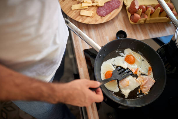 istock A young man frying the eggs in the kitchen 1297852965