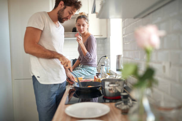istock A young couple in love preparing breakfast in the kitchen. Cooking, together, kitchen, relationship 1297853530