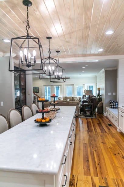 istock Large renovated white kitchen with textured subway tile, black iron lights and pine hardwood flooring 1297854777