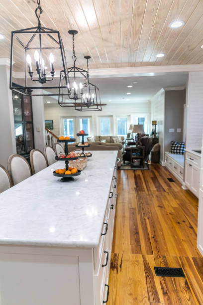istock Large renovated white kitchen with textured subway tile, black iron lights and pine hardwood flooring 1297854911