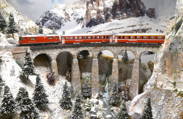 Florence, ITALY- October 2020: Model railway with Swiss Bernina Express Train on viaduct. Winter ambientation.