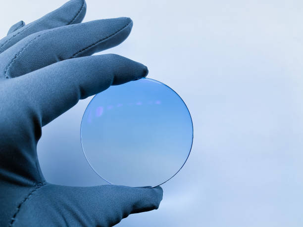 istock optical sun lens with blue antiglare in hand with glove on light background. 1297856172