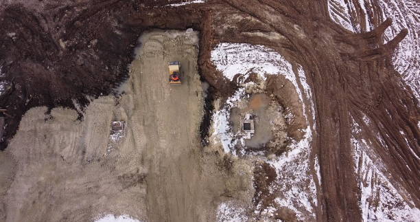 istock Soil preparation before construction of the object. Special equipment in the press soil before pouring the foundation. Shooting from above by a drone hitting the bottom of the roller. Earthworks 1297858384
