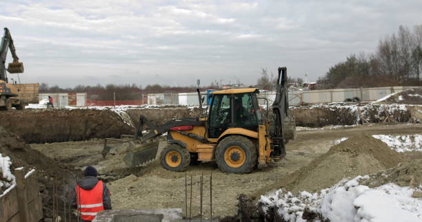 istock Loader excavator, bulldozer and roller work on construction site. Machines perform excavation work. Compaction of soil and rubble for residential buildings. Construction work 1297858602