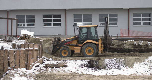 istock The bulldozer works on a construction site with sand, side view. New Big Tractor, a bulldozer on wheels on a sandy road on a construction site levels the site for the construction of real estate 1297859462