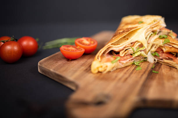 istock Crepes, thin pancakes with ham, cheese, mushrooms and tomatoes. 1297860454
