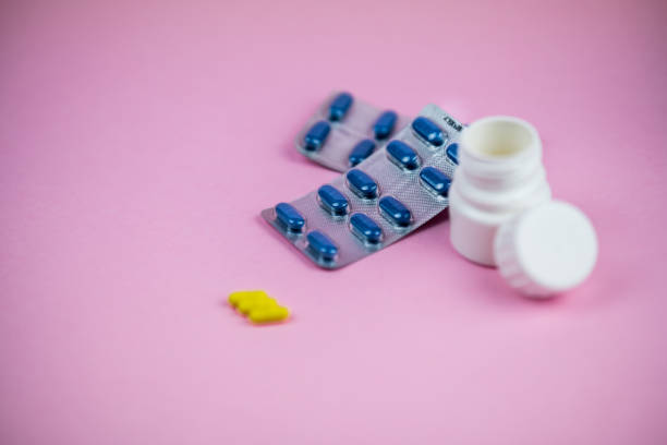 istock pill bottle on a pink background with drug blisters 1297860810