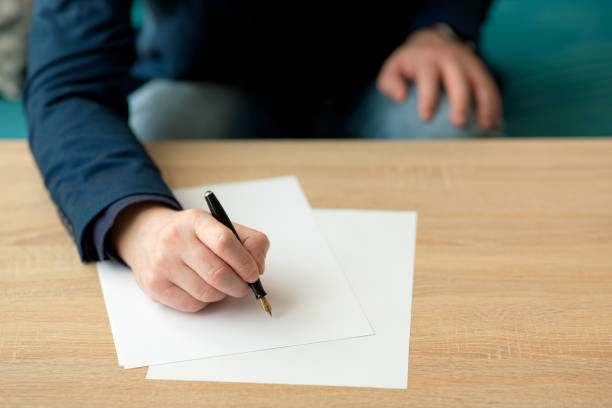 istock Businessman writes a letter or signs a document 1297861618