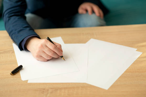 istock Businessman writes a letter or signs a document 1297861619