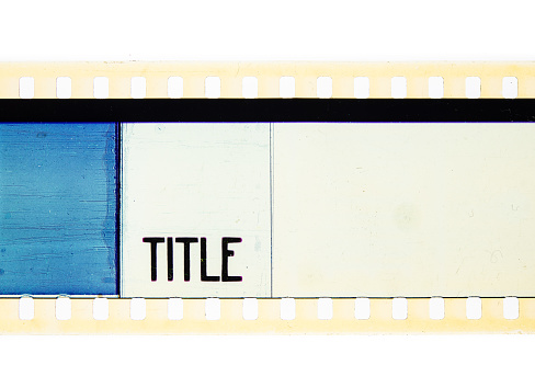 Extreme close up of 35mm movie film strip with title text message on azure