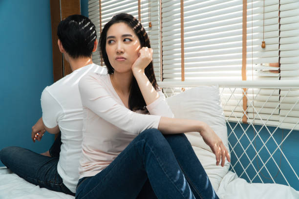 istock Unhappy Couples sitting behind each other on the bed and avoid talking or looking at each other, Cause of relationship problems and having misunderstanding or disagreement. Family problems concept 1297864258