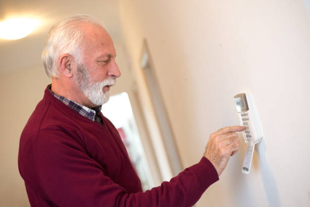 istock Senior man setting up home alarm 1297865991