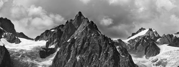 istock Panoramic view on high snowy mountains with glacier and cloudy sky 1297866870