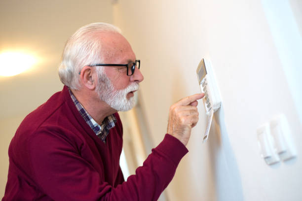 istock Senior man setting up home alarm 1297868669