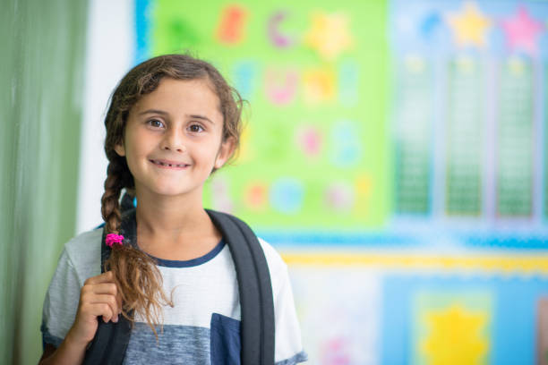 istock Smiling school girl in classroom 1297873791