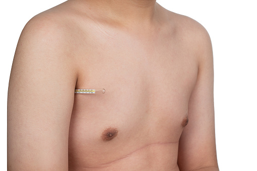 Glass thermometer under the boy's arm, hand or armpit. Temperature measurement body. The boy holds under his arm a means of measuring the temperature of the human body.