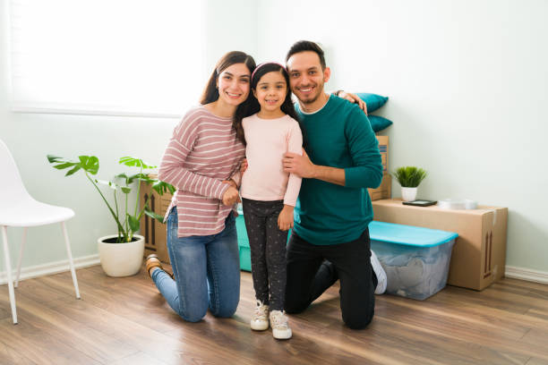 istock Latin parents smiling with their daughter during moving day 1297875623
