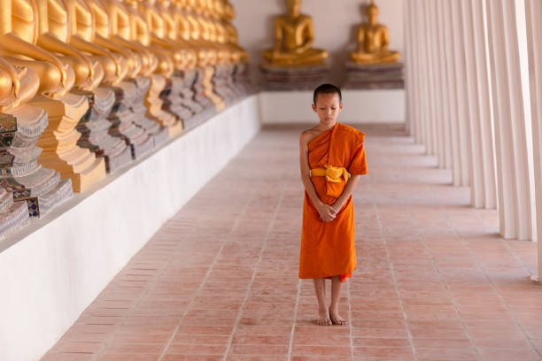 istock Young novice monk walking for meditation at Wat Phutthai Sawan temple 1297875700
