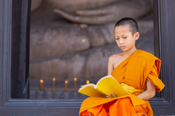 istock Young novice monk reading a book in Wat Phutthai Sawan Temple 1297875706